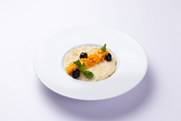 Porridge with pumpkin in a plate on a white background.