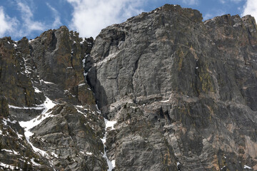 Fototapeta premium Rugged Granite Cliff Face with Snow Patches in Rocky Mountain National Park, Colorado
