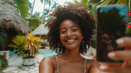 A woman is smiling and taking a picture of herself with a cell phone