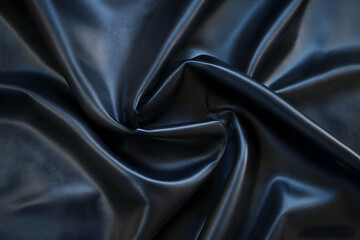 Fototapeta premium A close-up of dark, glossy fabric with a swirling pattern.