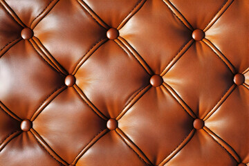 A close-up view of tufted brown leather upholstery with buttons.