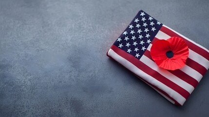 Fototapeta premium Reverent Tribute Poppy and Folded American Flag - A Heartfelt Commemoration of Fallen Heroes Bathed in Soft Warm Light