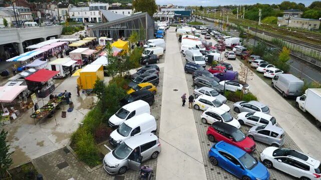A view from a bridge of some cars parked near a french open-air market. Laon, France - October 17, 2024 