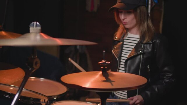 
a girl learns to play the drums