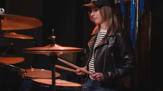 
a girl learns to play the drums