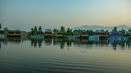 Obraz premium Kashmir, Srinagar India -Popular Srinagar Houseboats in Dal Lake. Colorful Shikara ride floating in Dal Lake aka Nigeen lake. Mountain range in Srinagar. Couple Honeymoon Destination.