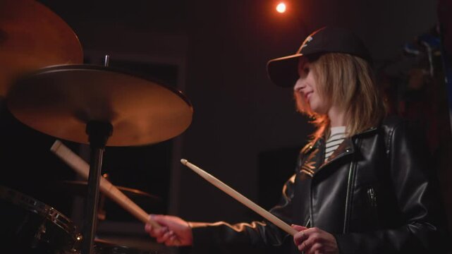 
a girl learns to play the drums