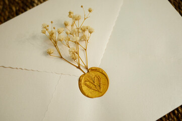 Elegant wedding seal and dried flowers on invitation