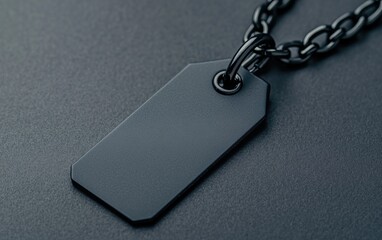 Fototapeta premium A black tag hanging from a chain on a dark surface, highlighting its sleek and minimalistic design.