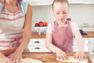 Mom, girl and hands with dough in kitchen, preparation and teaching child skills in home. Mama, daughter and love for helping with cookies, cooking wheat and kid learning to bake cake or pastry