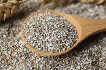 Wooden spoon with fresh rye bran, closeup