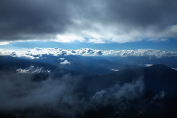Fog and clouds in the mountains, clouds and nebula on mountain peaks. Between sky and earth. Beautiful landscape, nature, travel concept.
