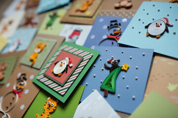 Paper quilling, colorful paper winter cards ready to be gifted. Hand made of paper quilling technique. Handicraft at home. Hobby, home office. Top view handmade Christmas greeting cards.