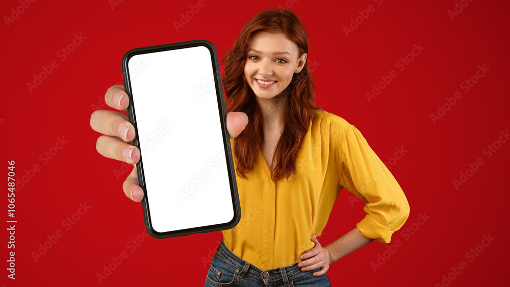 Poster millennial girl showing cellphone empty screen recommending mobile app posing on green studio backgr