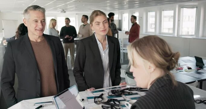 Male and female corporate professionals collecting ID cards at registration desk in convention center
