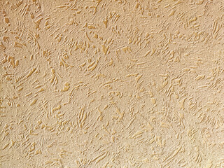 A textured beige wall surface displays a unique pattern with subtle variations in light and shadow, ideal for backgrounds
