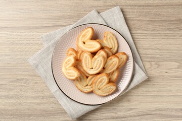 Delicious sweet palmier cookies on wooden table, top view