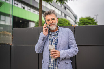 senior man talk on mobile phone on coffee break in front company