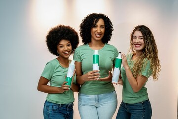 Diverse women in green shirts showcasing a hair product, highlighting beauty and diversity
