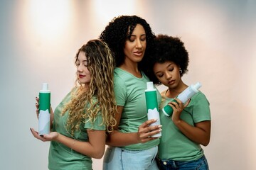 Diverse women in green shirts showcasing a hair product, highlighting beauty and diversity