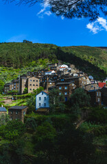 hillside village with traditional stone houses nestled among lush greenery