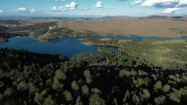 Nature of western Serbia in early autumn on a sunny warm day. Aerial sunset view from a drone of Lake Ribnichko in Zlatibor national park, next to the cable car leading to Mount Tornik