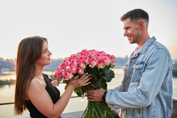 Young couple with a bouquet of pink roses