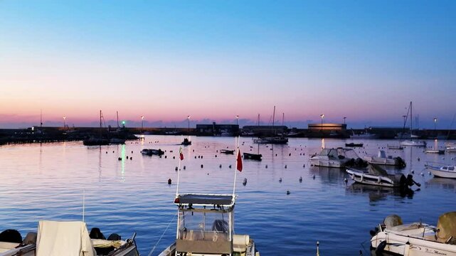 Sundown in the port of Anzio in Italy. Reflections in the water and vivid colors illuminate the scene with the boats moving. Located on the Tyrrhenian Sea dedicated to Sea dedicated to tourism
