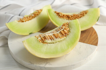 Fresh cut honeydew melon on white wooden table, closeup