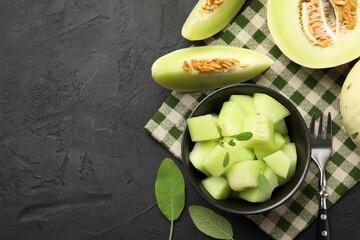 Slices of yummy melon on dark table, flat lay. Space for text