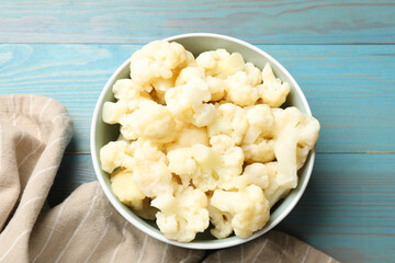 Tasty cooked cauliflower on light blue wooden table, top view