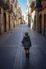Little girl walking alone down the street