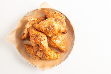 Freshly baked croissants with almonds on a plate