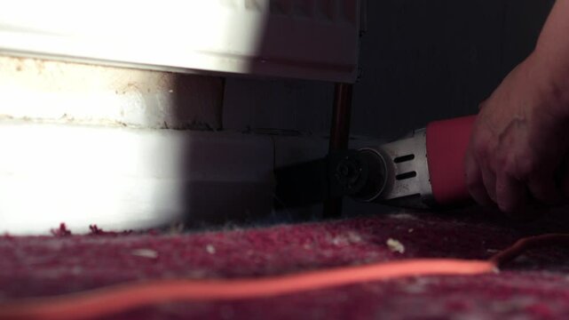 Using a power multi tool to saw house baseboards