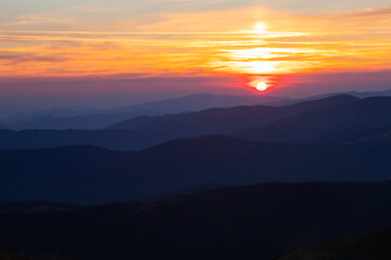 Obraz premium endless mountain ranges look like the sea and the sun rising over the horizon