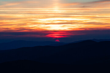 Fototapeta premium amazingly beautiful multicolored sky in the mountains at sunset. red sun