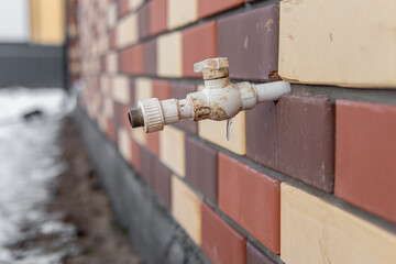 Outdoor plumbing edge. An icicle of frozen water. External water faucet