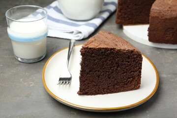 Piece of tasty chocolate sponge cake served on grey table, closeup