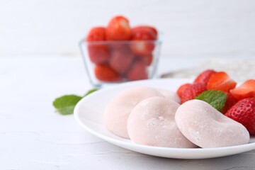 Delicious mochi and strawberries on white table, closeup