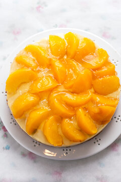 Cake with vanilla cream, peaches and white glaze 