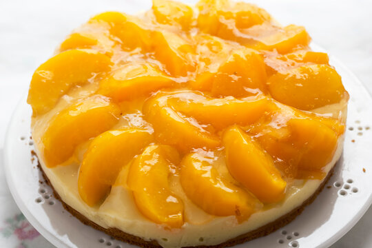Cake with vanilla cream, peaches and white glaze 