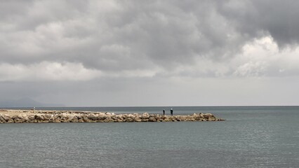 Sea, beach and pebbles, clouds in the sea.
