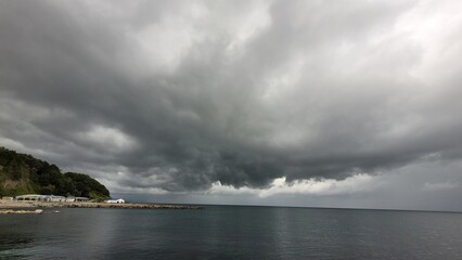 Sea, beach and pebbles, clouds in the sea.
