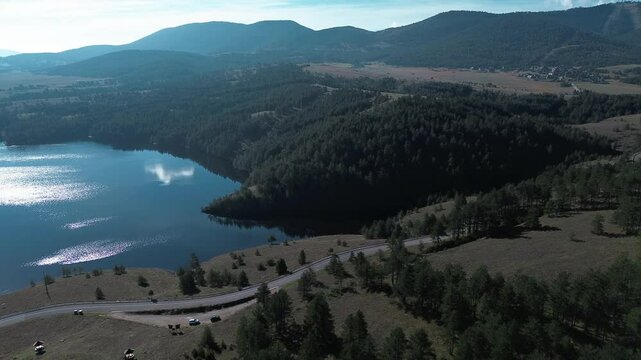 Nature of western Serbia in early autumn on a sunny warm day, Zlatibor town popular among tourists. Aerial view from a drone of Lake Ribnichko, next to the cable car leading to Mount Tornik