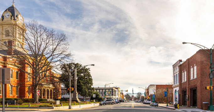 MONROE, NC, USA-28 JAN 2023: Wide angle view down  Main Street past Court House toward First Baptist Church.  Sunny winter day.