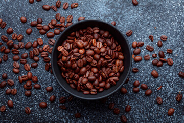 Roasted coffee beans in bowl. Rusty background for coffee shop menu. Top view and copy space.
