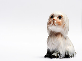 In tis photoillustration Vintage porcelain figurine of dog on white background