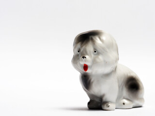 In tis photoillustration Vintage porcelain figurine of dog on white background