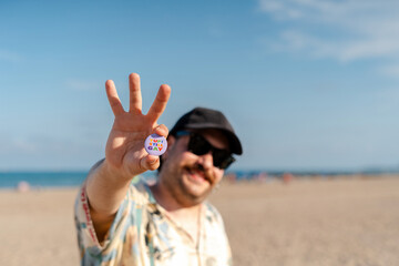 Tourist showing yup still gay button on the beach during summer vacation