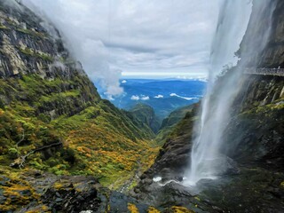 Fototapeta premium Majestic waterfall in lush mountain landscape.